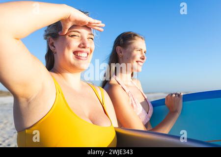 Two young Caucasian women enjoy a sunny beach day Stock Photo