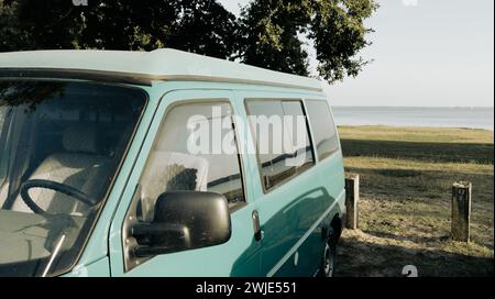 camper Motorhome RV campervan parked on lake side beach for night Stock Photo