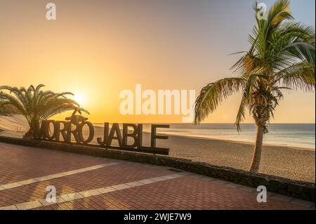 Bask in the warm glow of sunset at Morro Jable, Fuerteventura, where golden sands meet tranquil Atlantic waters—a photographer dream Stock Photo