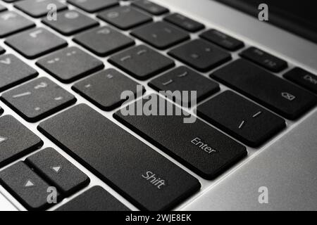 Laptop keyboard with black keys and aluminum metal case close-up. Stock Photo