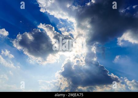 Sunbeams breaking through dramatic cumulus clouds. Weather change from stormy to sunny. Hope or religion concept. Stock Photo
