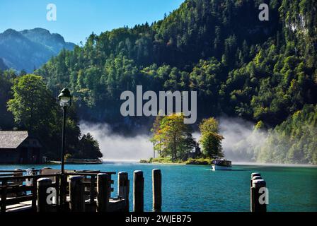 An electric-powered excursion boat emerges from the fog on Königssee, or King's Lake, Bavaria, Germany. Stock Photo