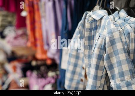 Children clothes hanging on hangers in the shop Stock Photo