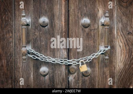 Ancient door closed by a padlocked bolt Stock Photo
