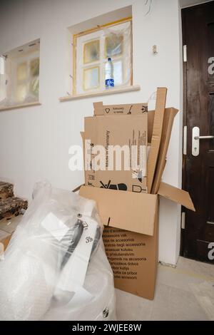 Paris, France - Jun 8, 2020: A cluttered room during moving day or kitchen installation, with open cardboard boxes and items wrapped in bubble wrap - cardboard waste for recycling Stock Photo