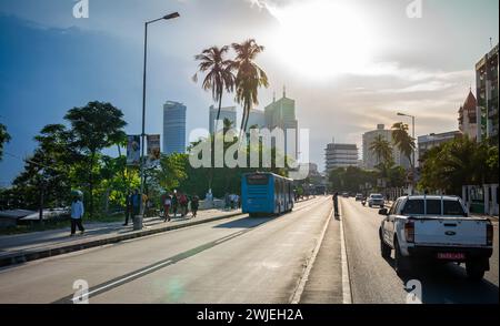 Traffic drives down Kivokoni Road towards tall buildings in the Ilala central business district in Dar es Salaam, Tanzania Stock Photo