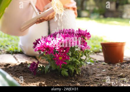 Gardener tends to vibrant flowers outdoor Stock Photo