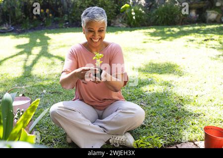 A mature biracial woman enjoys gardening outdoor Stock Photo