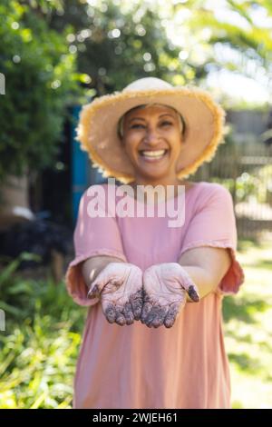 A mature biracial woman enjoys gardening outdoors Stock Photo