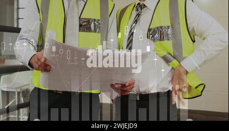 Two male architects discuss plans with graphs Stock Photo