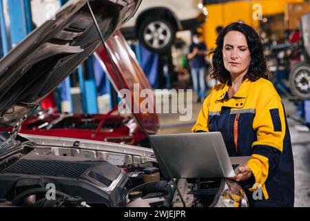 auto mechanic car engineer using laptop computer tuning ECU diagnosis analysis monitor engine problem in garage auto service Stock Photo