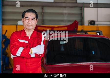 Happy senior professional Asian male mechanic garage worker happy working replace maintenance car service in auto workshop Stock Photo