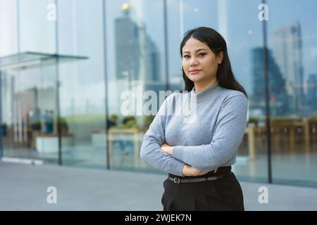 Portrait Indian Asian smart businesswomen confident arm crossing standing against office building outdoors Stock Photo