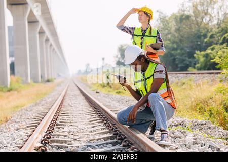 Engineer female railway tracks service team working on site survey check maintenance inspection train track for new construction and safety check Stock Photo