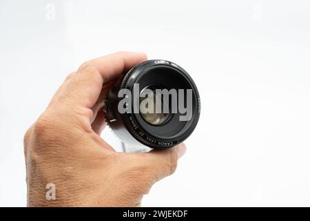 Valencia, Spain - August 8, 2021: Product photo. Close up image of a hand holding a Canon EF 50mm f/1.8 II photographic lens, showing it in detail on Stock Photo