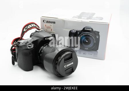 Valencia, Spain - August 8, 2021: Canon 70D DSLR camera with 18-135mm lens and its package with focus on the lens cap over white background. Product p Stock Photo