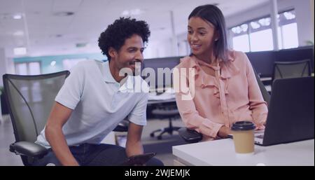 Biracial couple collaborates in a modern office setting Stock Photo