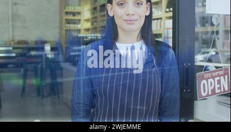 Image of data processing over caucasian female shop assistant smiling Stock Photo