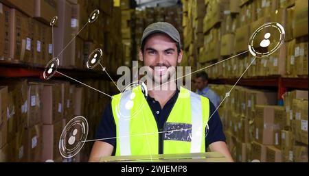 Image of network of conncetions with icons over caucasian male worker warehouse Stock Photo