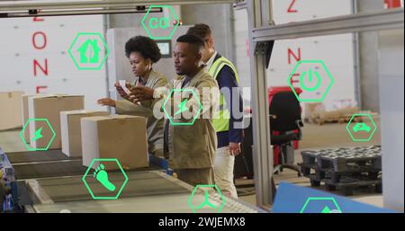 Image of eco icons and data processing over diverse people working in warehouse Stock Photo