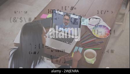 Multiple changing symbols against woman having a image call with male colleague on laptop at office Stock Photo