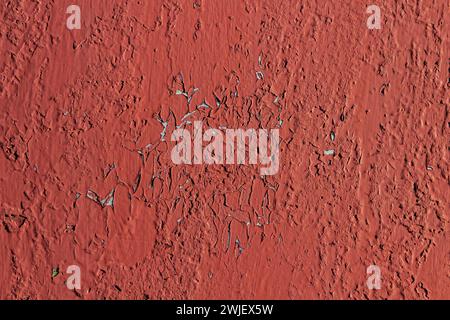 Red peeling paint on a metal surface. Texture. Stock Photo