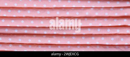 Texture of pink fabric with white dots. Crumpled fabric. Top view. Stock Photo