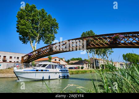 Salleles-d'Aude (south of France): barge passing under a footbridge on the “Canal de Jonction” linking up with the Canal du Midi Stock Photo