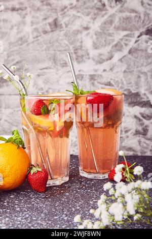 Aesthetic detox cocktails with citrus fruits and strawberries. Vitaminized summer detox water. Low-alcohol drinks decorated with gypsophila. Stock Photo