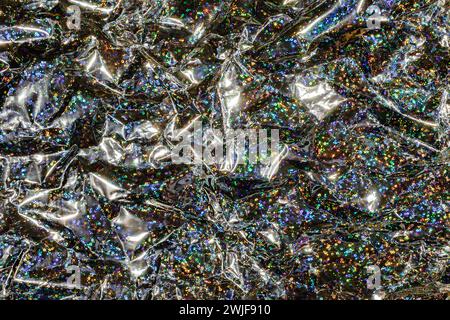 Crinkled plastic wrapping with sparkling details creating an abstract glittering background Stock Photo