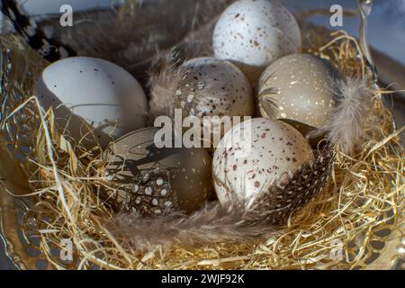 Multi-colored wooden Easter eggs lie in a paper nest Stock Photo