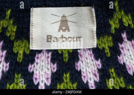 Barbour logo badge on woman's Barbour knitted jumper made of wool, cotton and polyamide Stock Photo