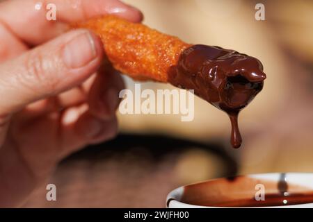 Having breakfast churros, porras, with a cup of hot chocolate in El Campello, Spain Stock Photo