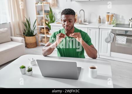 young african american deaf man using sign language during video call on laptop at home Stock Photo