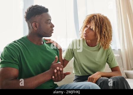 black man showing help gesture while communicating with worried girlfriend and using sign language Stock Photo