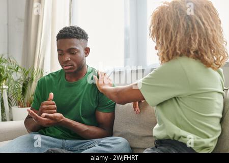 black man showing help gesture while communicating with girlfriend and using sign language Stock Photo