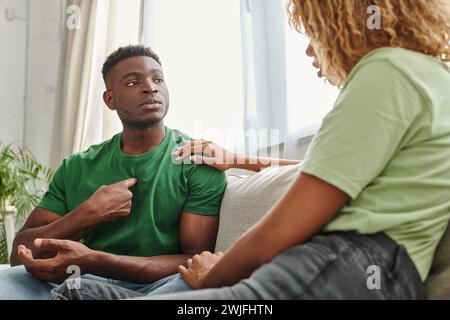 black man pointing at himself while communicating with girlfriend and using sign language Stock Photo