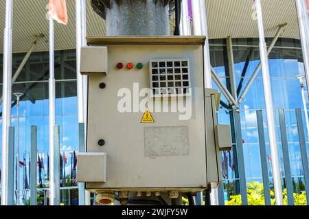 Urban caution: electrical panel box with warning sign on sleek street pole Stock Photo