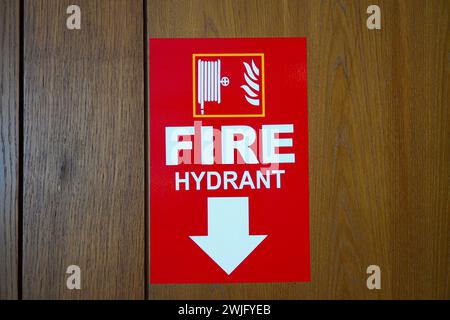 Red sticker with fire extinguisher sign on wooden wall Stock Photo