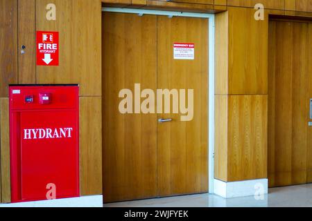 Red sticker with fire extinguisher sign on wooden wall Stock Photo