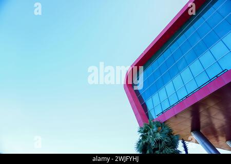 architectural elegance: a striking image featuring a modern red building set against a clear blue sky background Stock Photo