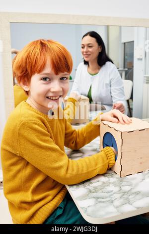Portrait of a red-haired boy during classes with a child development specialist. Pediatric speech and language therapy Stock Photo