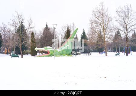 Colorful park with plastic swings and slides under snow in winter Stock Photo