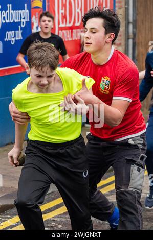 Youths take part in the annual 'Hand ba' is played in Scottish borders town Jedburgh. Traditionally the first ever game was played with an Englishman’s head,  the ribbons on the ball symbolise his hair. The teams (Uppies and Doonies) are chosen by where they live – Uppies are those born to the South and Doonies to the North of the Market Cross.  Credit: Euan Cherry Stock Photo