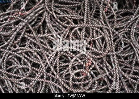 A pile of rope on the ground a Campbelltown Harbour, Scotland that has been used in the fishing industry. Stock Photo