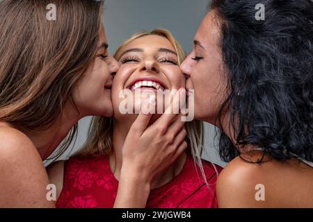 Amidst a festive celebration, three friends share a close and affectionate moment, full of laughter and joy Stock Photo