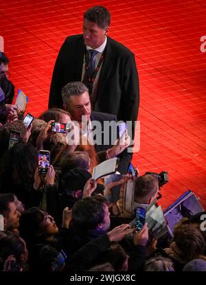 Berlin, Germany. 15th Feb, 2024. Producer Matt Damon (Competition film 'Small Things Like These') takes selfies with fans on the red carpet in front of the Berlinale Palast during the opening of the 74th Berlinale. The 74th Berlin International Film Festival will take place from February 15-25, 2024. Credit: Soeren Stache/dpa/Alamy Live News Stock Photo