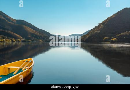 Landscape of a river valley with a yellow boat reflected in the serene waters. Nature travel concept Stock Photo