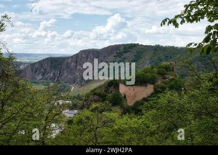 Bad Munster, Germany - May 12, 2021: Green plants and trees growing on castle ruins on a hill with Rotenfels in the background on a spring day in Rhin Stock Photo