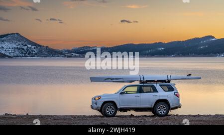 Loveland, CO, USA - February 13, 2024: Toyota 4Runner SUV with Liteboat rowing shell on roof racks on a shore of Carter Lake in northern Colorado at w Stock Photo